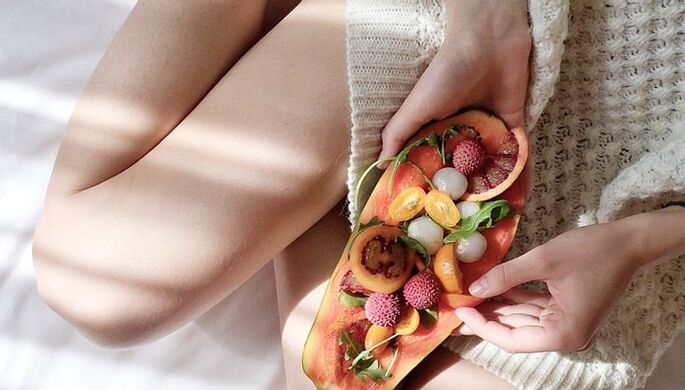 Fille avec papaye et autres fruits.